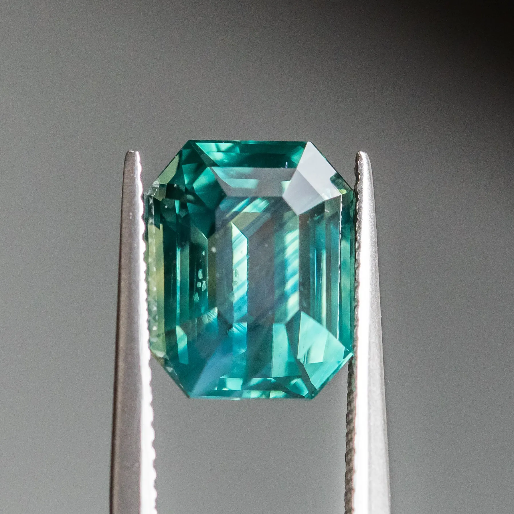 7.08CT EMERALD CUT MADAGASCAR SAPPHIRE, DEEP GREEN TEAL WITH COLOR ZONING, 11.17X9.07X7.07MM