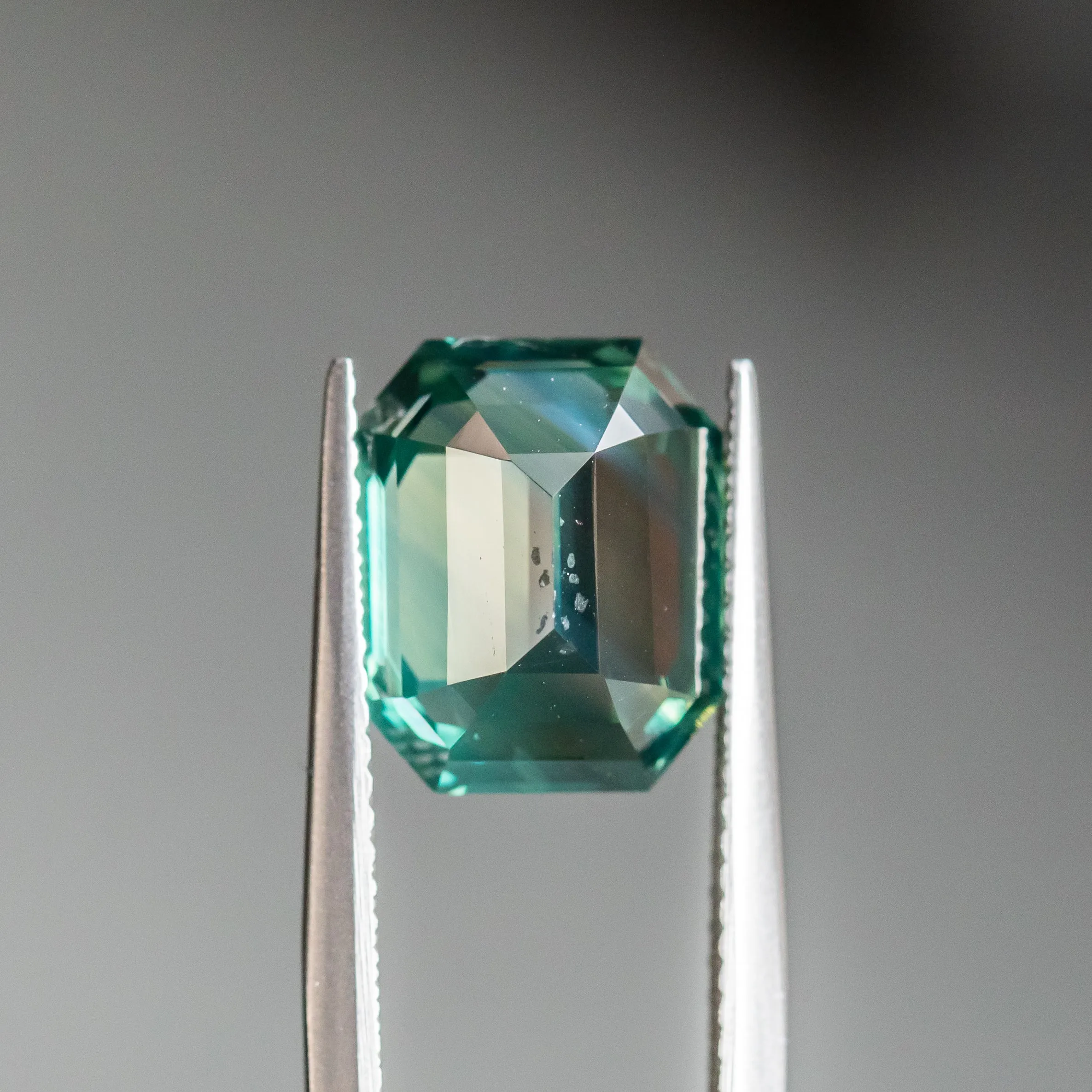 7.08CT EMERALD CUT MADAGASCAR SAPPHIRE, DEEP GREEN TEAL WITH COLOR ZONING, 11.17X9.07X7.07MM